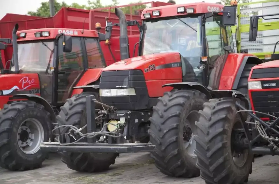 Czerwone traktory Case, w tym model MX135, gotowe do pracy na polu.